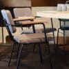 Comfortabele stapelstoel met armleuning aan een tafel