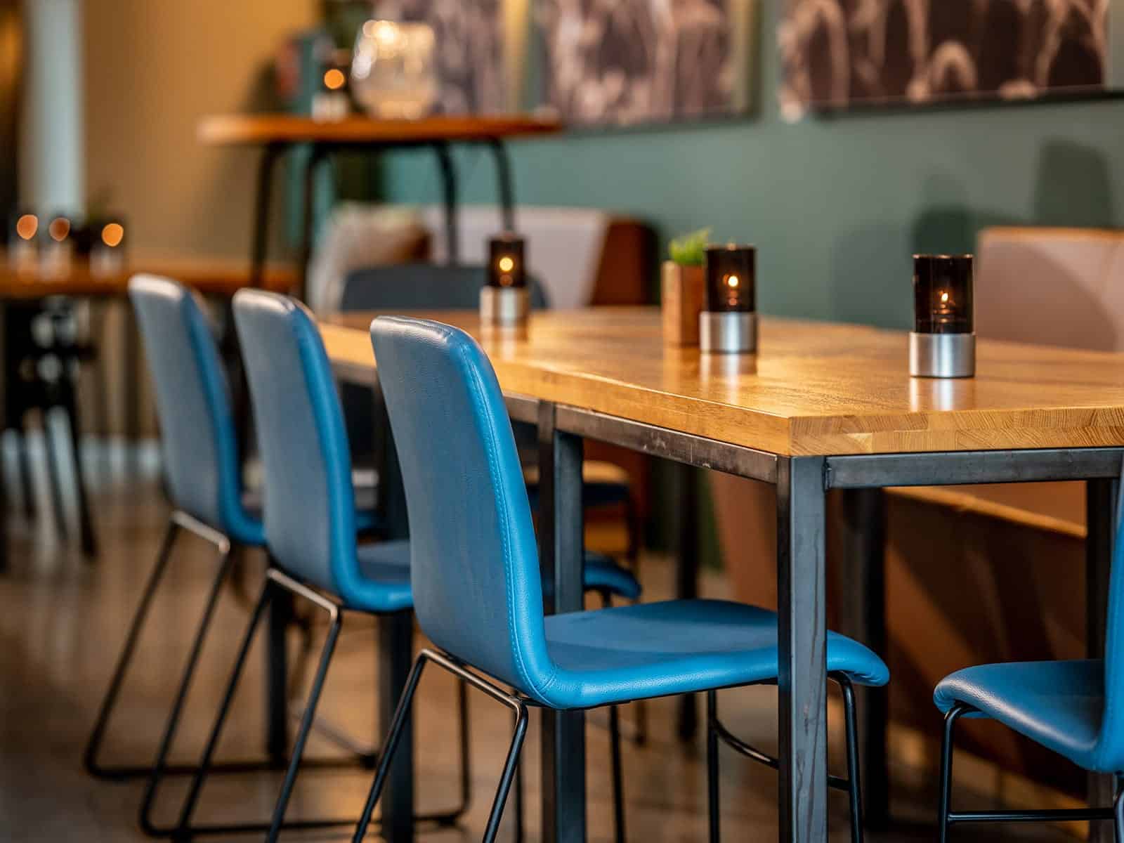 Eiken tafels met metalen onderstel in combinatie met blauwe kuipstoelen